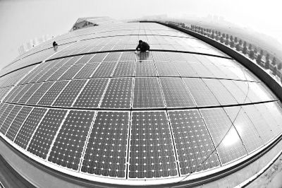 右图:光谷一企业工作人员正在维护屋顶太阳能光伏发电场。