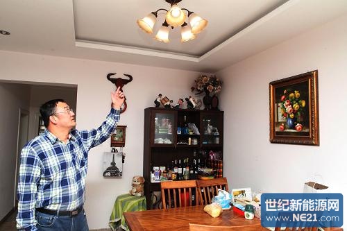 4月6日,申请个人卖电业务的居民董强在自家客厅向记者展示发电设备为自家灯光照明提供电能。新华社发