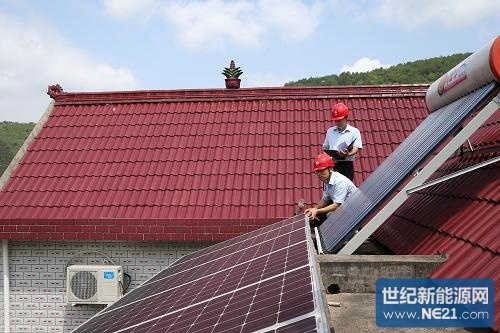 6月19日,兰溪市供电公司工作人员在为村民蒋林芳家的屋顶光伏组件做检查。新华社发(滕健摄)