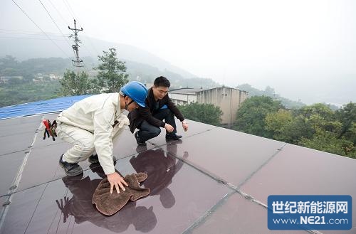 10月22日,田麒麟(右)和国家电网重庆北碚供电公司蔡家供电营业所的技术员许长江在太阳能电池板上进行巡检。近日,重庆北碚区施家梁镇施家村村民田麒麟家的光伏发电站顺利并入电网。田麒麟家的光伏发电站用40块、总面积约50平方米的太阳能电池板取代屋顶的彩钢棚,大约花费8万元。据国家电网重庆公司对外联络部负责人介绍,这个家庭光伏发电站总装机量为4千瓦,是目前重庆最大的居民光伏发电项目。新华社记者 刘潺 摄