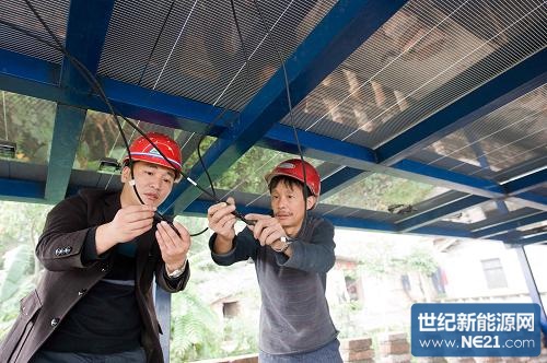 10月22日,田麒麟(左)在北碚区静观镇农村的亲戚家,指导工人安装他和亲戚共同出资兴建的农村光伏发电示范项目。新华社记者 刘潺 摄