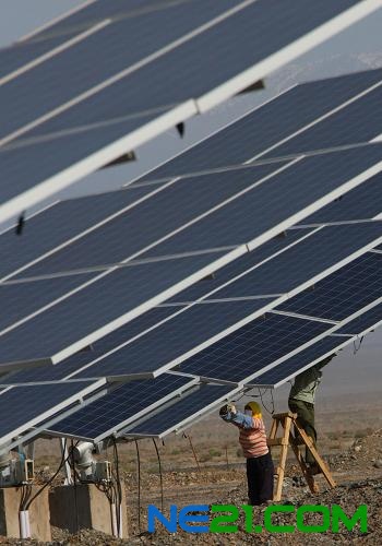 6月11日,工人在新疆哈密光伏发电站安装太阳能电池板组件。新华社发(普拉提 摄)