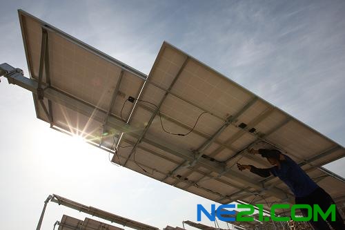 6月11日,工人在新疆哈密光伏发电站安装太阳能电池板组件。新华社发(普拉提 摄)