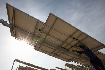 6月11日,工人在新疆哈密光伏发电站安装太阳能电池板组件