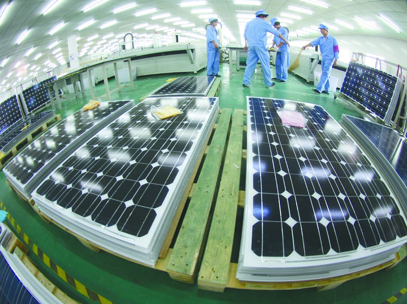 江苏一光伏新能源企业职工在生产太阳能电池组件。