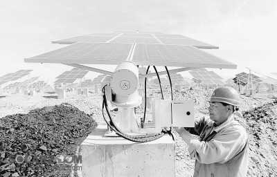 工人在新疆哈密光伏发电站调试太阳能电池板组件